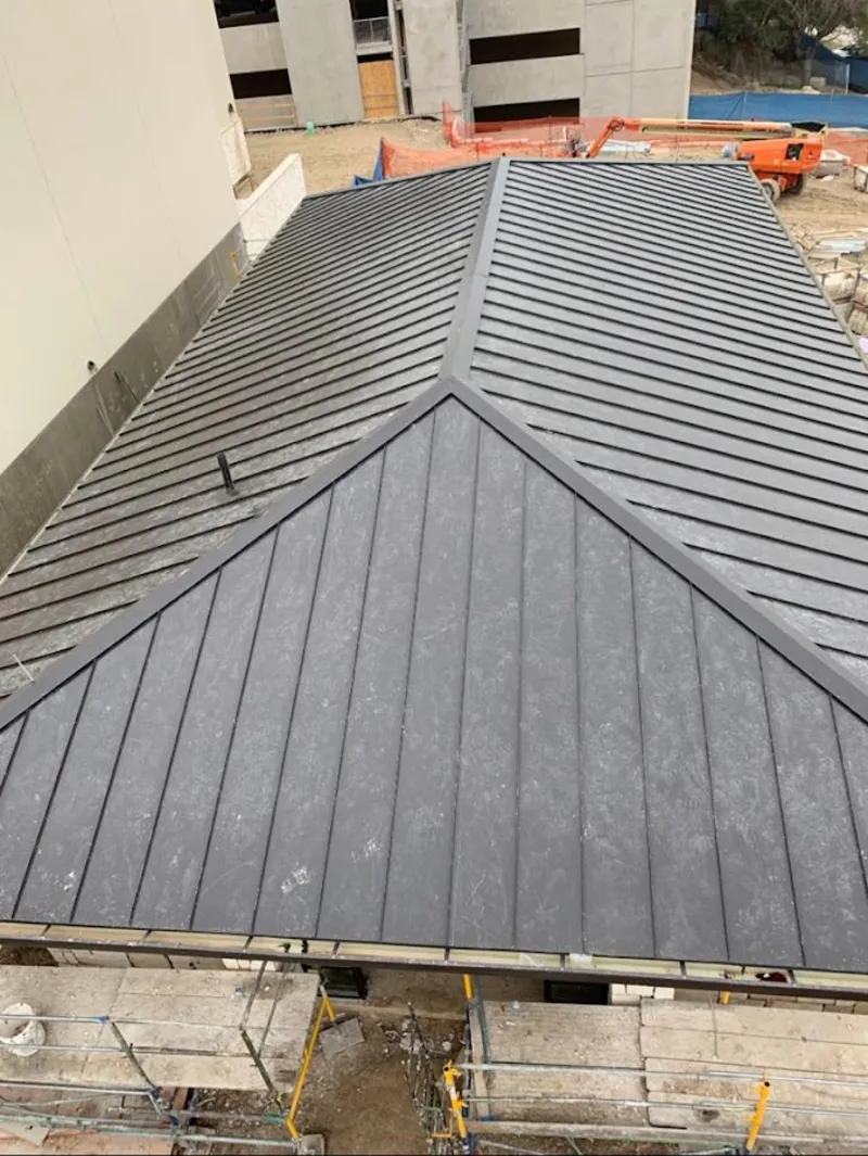 Commercial metal roof construction with crane equipment in Dallas